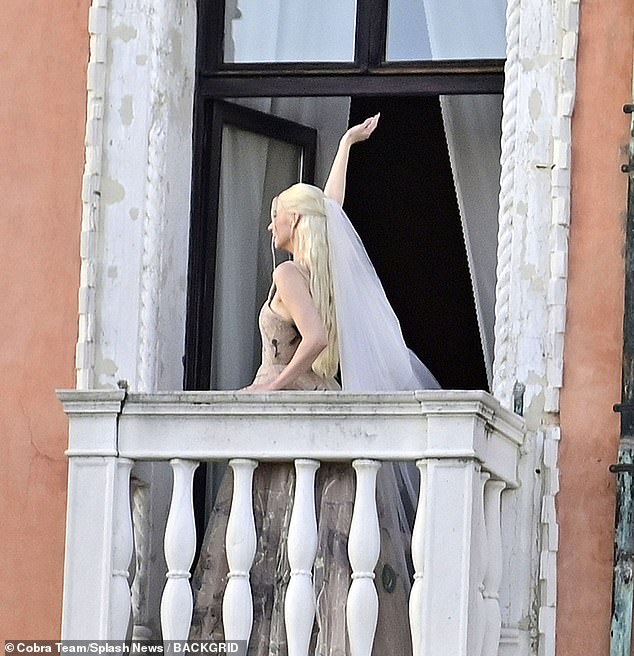 The actress waved as she turned and left the Venetian balcony, giving fans a glimpse of her traditional floor-length white veil