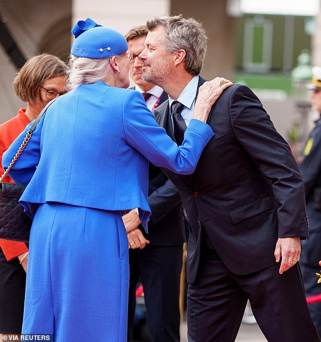 The Danish monarch offered her eldest son, Crown Prince Frederik, a warm kiss and a hug (photo left)