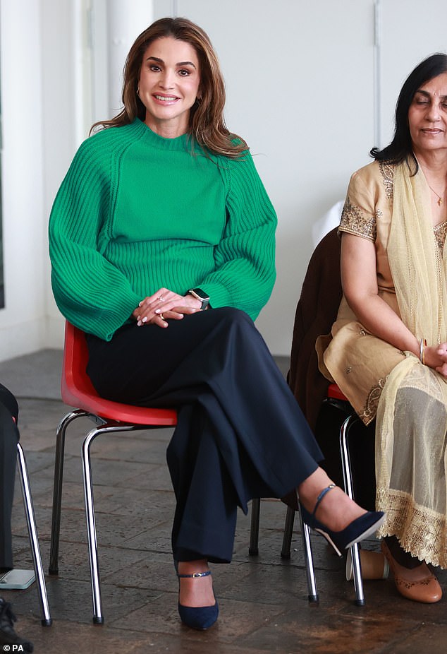 She looked chic in a bright green sweater which she teamed with navy blue trousers and stilettos