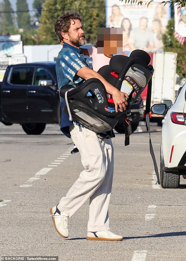 Doting dad: The star carried a car seat as he left