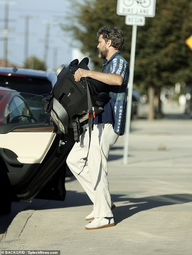 Here he goes: The actor loaded a car seat into his car before leaving