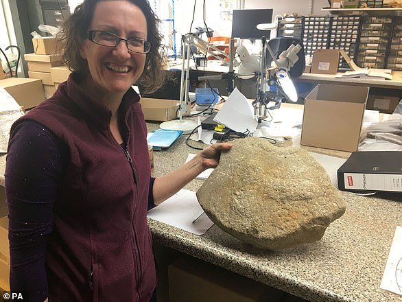 The millstone was examined by experts from the Museum of London Archeology Headland Infrastructure and Oxford Archaeology.  In addition to carving the phallus on the top of the millstone, the team discovered two crosses engraved on its perimeter.  In the photo, Oxford archeology expert Ruth Shaffrey poses with the phallus-bearing millstone