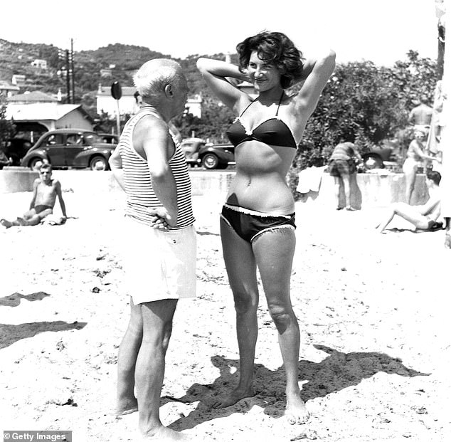 Picasso with a young woman in a bikini on a beach in France in the 1960s
