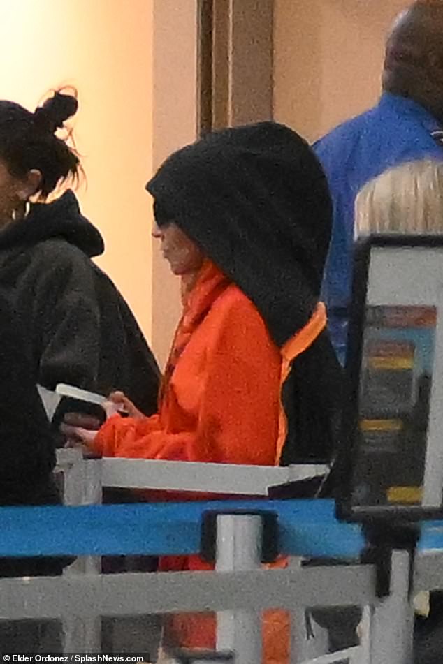 Waiting her turn: The seven-time Grammy winner – who gets 39 million monthly listeners on Spotify – clutched her US passport as she waited patiently in a security line with her entourage