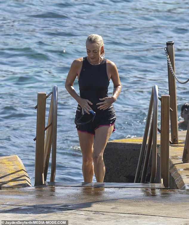 The radio host wore a black cut-out swimsuit and black board shorts