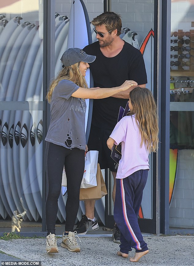 Elsa waited outside a surf shop with her daughter India Rose, 11, while her husband Chris, 40, bought a surfboard and loaded it into their Ute.