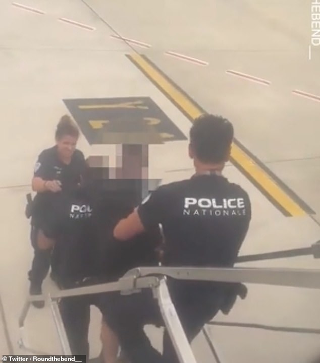 A third officer was pictured at the bottom of the stairs, ready to help remove the tourist