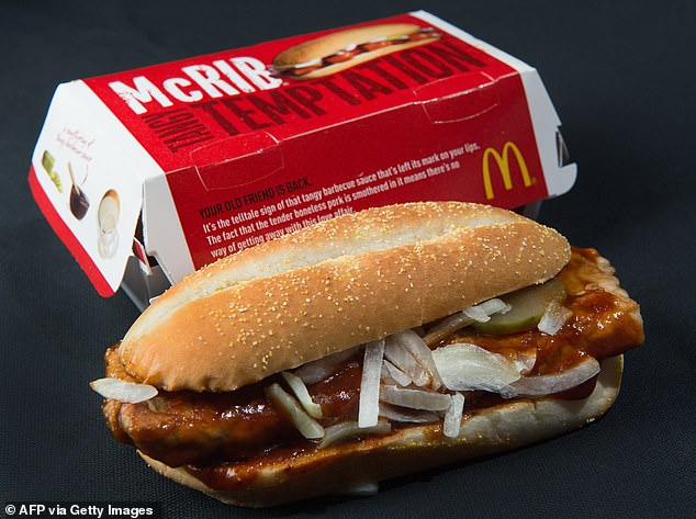 McRibs consist of a seasoned boneless pork patty covered in barbecue sauce, topped with onions and dill pickles in a toasted bun.