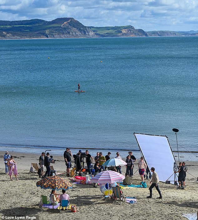 Beautiful scenery: The cast gathered on this beautiful day by the sea as they shot the new scenes on a paddleboard