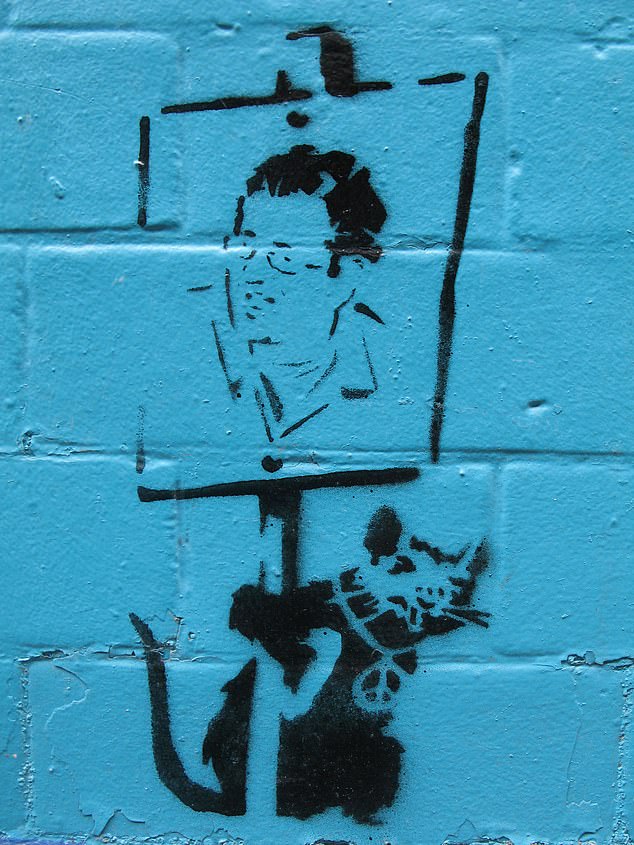 The Mail on Sunday shows stencil graffiti on an office building in East London, believed to be by Banksy, with an image similar to the photo of Robin Gunningham, believed to be his true identity