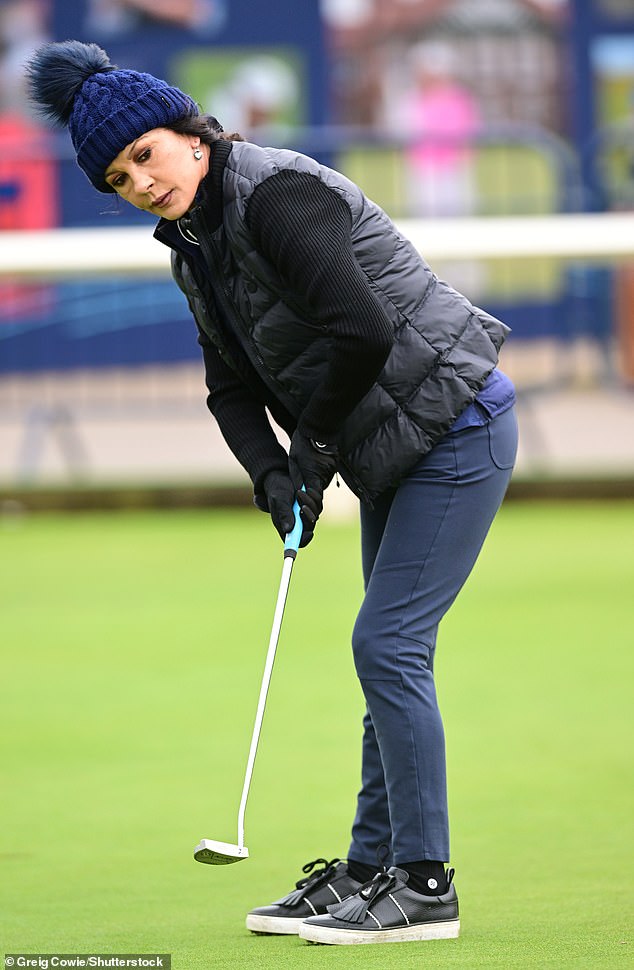 Casual: She wore black gloves and completed the look with sneakers as she strolled along the greenery