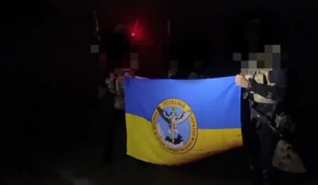 The soldiers were then seen waving a Ukrainian flag as they arrived on the coast of Crimea