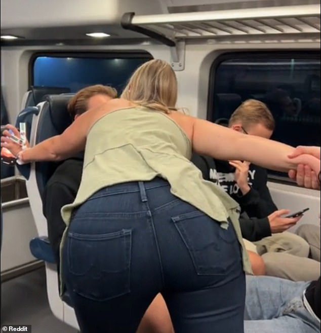 The 'Karen' towers over a group of tourists as they chat with each other in their seats.