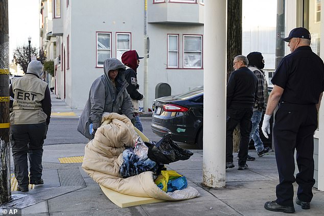 A homeless woman moves her belongings after being contacted by the San Francisco Homeless Outreach Team's Encampment Resolution Team