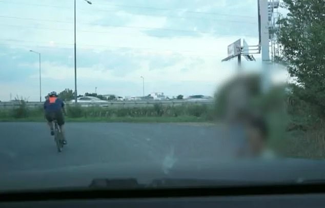 The pair then unfold in broad daylight and in full view of bystanders along the road, including a cyclist who almost catches the pair.