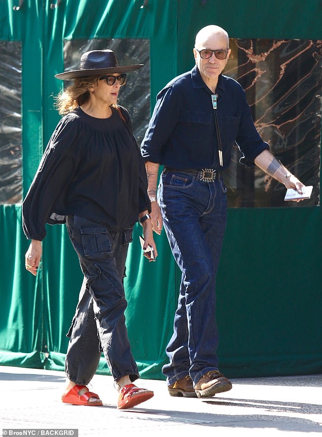 Dynamic duo: Filmmaker Rebecca wore a loose blue top and cargo pants, paired with red sandals and a fedora hat