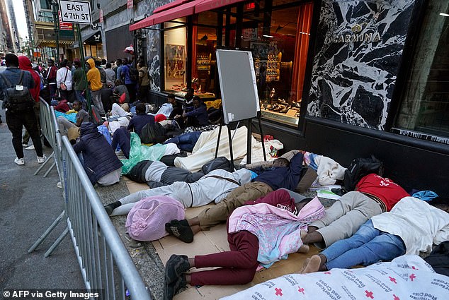 Hundreds of migrants sleep early on August 1 in line for placement at the intake center of the Roosevelt Hotel in New York