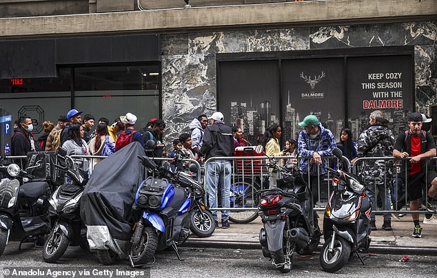 Asylum seekers line up outside the historic Roosevelt Hotel, converted into a city-run shelter for newly arrived migrant families in New York City