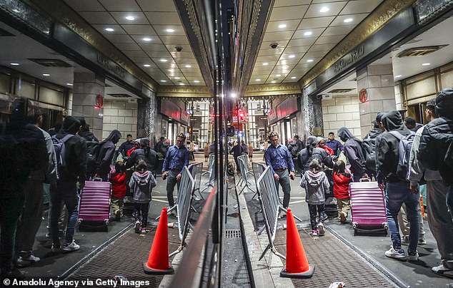 A line of asylum seekers lines up outside the Roosevelt Hotel, which has been converted into a city-run shelter for newly arrived migrant families