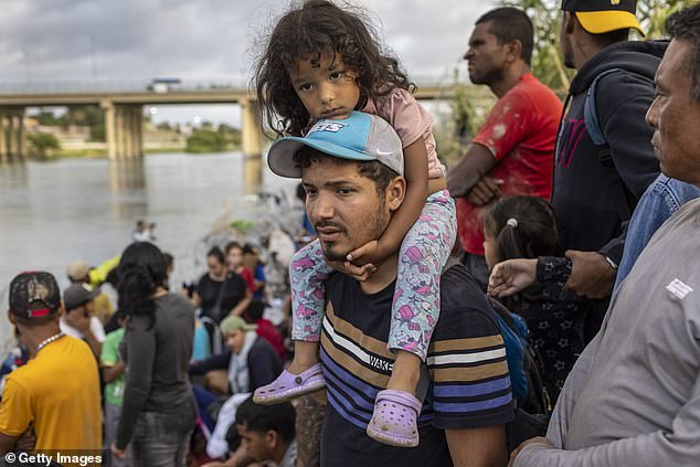 A family from Venezuela awaits treatment by U.S. agents after crossing the Rio Grande from Mexico into the United States on September 30