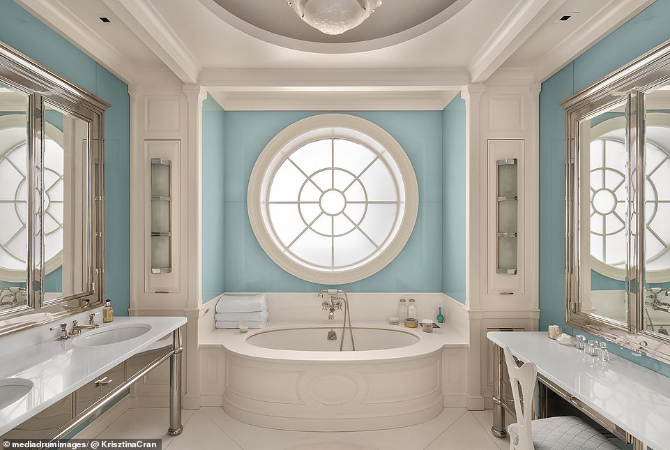 The master bathroom has one of the home's most striking features: a large circular window directly above the lavish bath