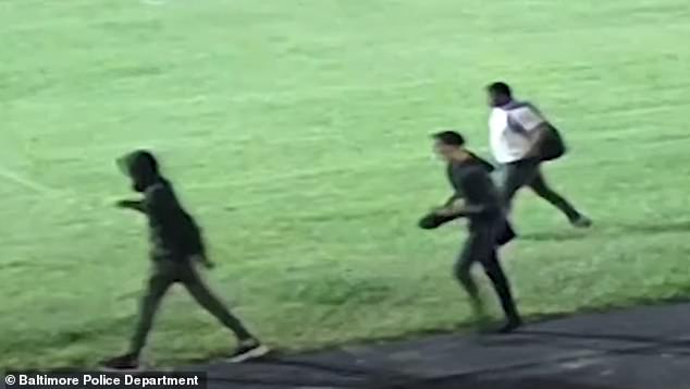 The video then cuts to show three men, at least one wearing a backpack, walking in the opposite direction