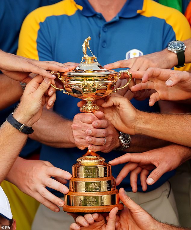 Captain Luke Donald of Team Europe holds the Ryder Cup Trophy with players