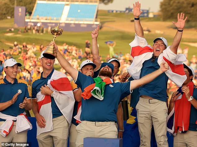 Ireland's Shane Lowry and the European team roar with joy as he lifts the Ryder Cup alongside (L-R) Matthew Fitzpatrick, Justin Rose, Tyrrell Hatton, Ludwig Aberg, Rory McIlroy and Viktor Hovland during the official presentation