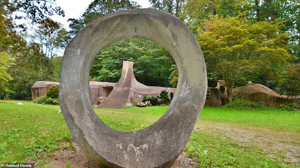 Sculptural elements that reflect the aesthetics of the house are located in the garden.  Seen is one of them on the lawn