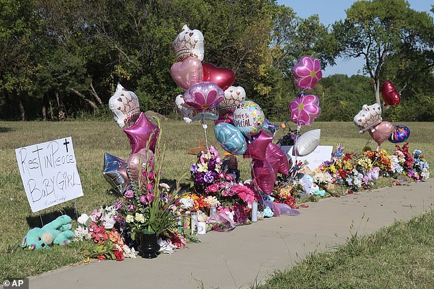 Zoey Felix, a 5-year-old girl, is honored with a makeshift memorial of flowers, balloons, signs and toys along a sidewalk