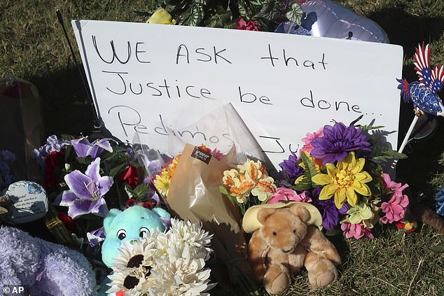 A sign calling for justice sits among toys, balloons and flowers in a makeshift memorial in Zoey's honor