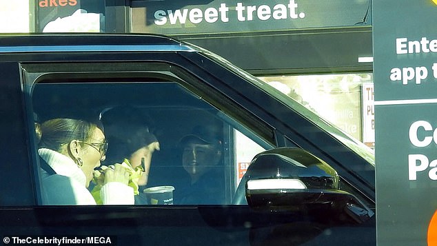 Yum!  The singer dug into her burger as they rolled through the drive-thru