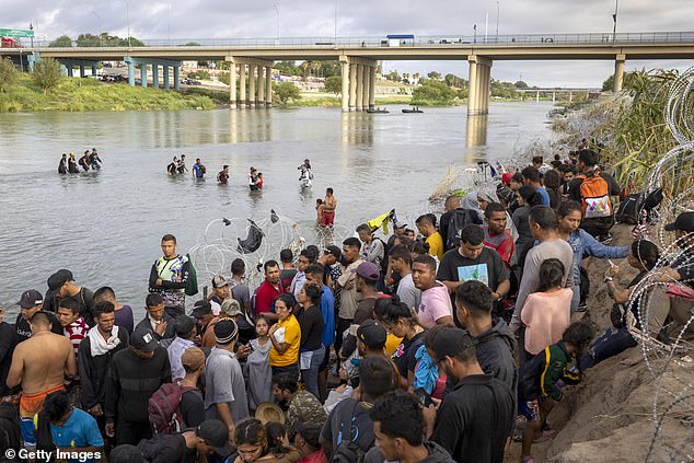 Asylum seekers await processing by U.S. Border Patrol agents after crossing the Rio Grande from Mexico into the United States