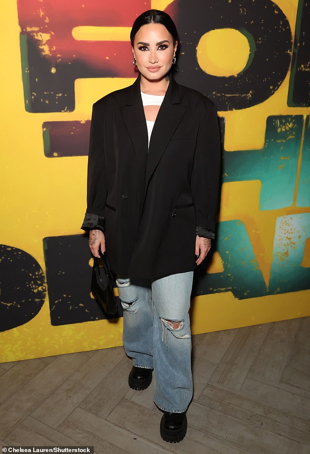 Looking good: They were joined by Demi Lovato, 31, who also wore a punky look for the event, wearing a white top under an oversized black blazer and ripped jeans