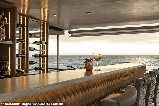 The boat features a large bar where guests can enjoy a range of drinks while looking out at the ocean