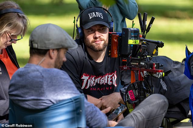 Behind the camera: Tom looked worlds away from his former character as he sported an unshaven look complete with dark baseball cap and casual hoodie