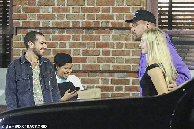 A trio of fans surround Kelce as he arrives at the Golden Ox in Kansas City Thursday night