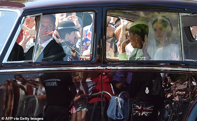 Pictured: Meghan and her mother, Doria Ragland, walk down the long promenade in a maroon Rolls-Royce Phantom IV as they arrive for her wedding ceremony