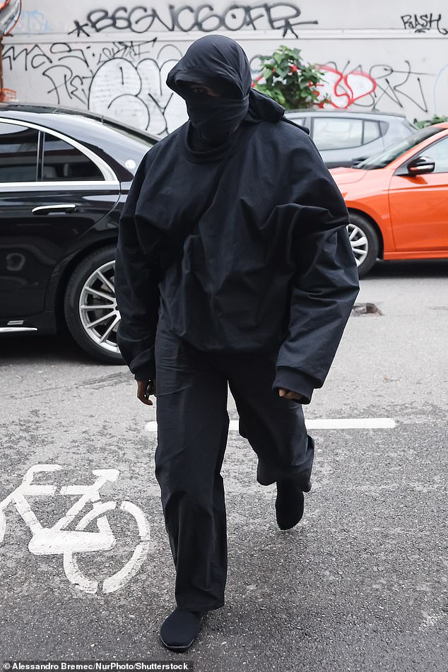 Quirky: Kanye tried to keep his face hidden as he was spotted walking around Florence in an all-black outfit with a hood around his face