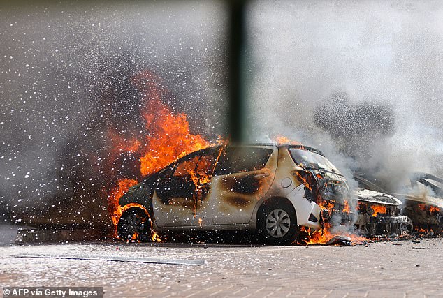 Cars on fire after a rocket attack from the Gaza Strip into southern Israel on October 7