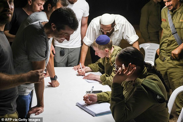 Israeli reservists line up to register for duty in a northern Israeli town on October 7, after the Palestinian militant group Hamas launched a large-scale surprise attack on Israel