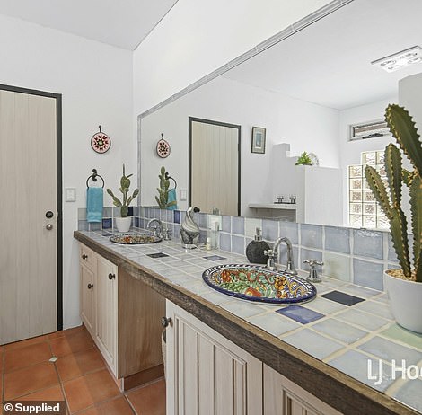 Back inside, the wet areas feature hand-painted ceramic basins that were imported from Mexico and a bathroom has a luxury bath sitting under a glass brick window.