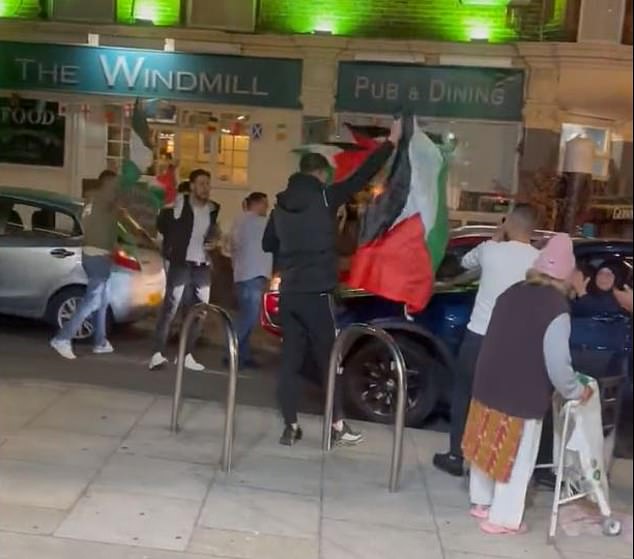 People celebrating Hamas atrocities in Israel yesterday outside a cafe in Acton, West London