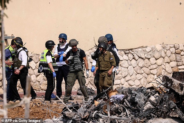 Hamas terrorists launched a massive attack on Israel on Saturday.  Pictured: Rescue workers gather in front of an Israeli police station in Sderot after it was damaged in fighting to drive out Hamas militants stationed inside on Sunday, October 8