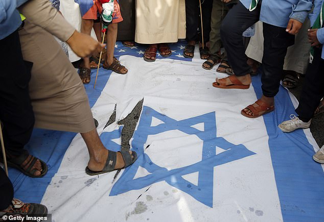 Protesters were also seen tearing up Israeli and American flags