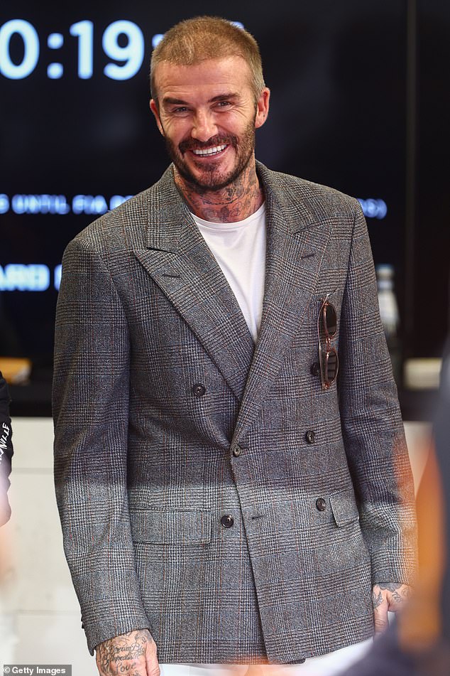 1696782651 0 David Beckham flashes a smile as he joins a group