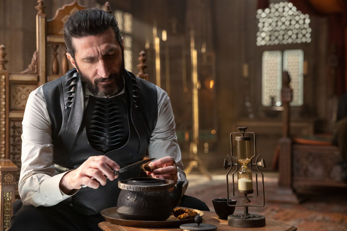 Ishamael (Fares Fares) sitting and playing with a sword