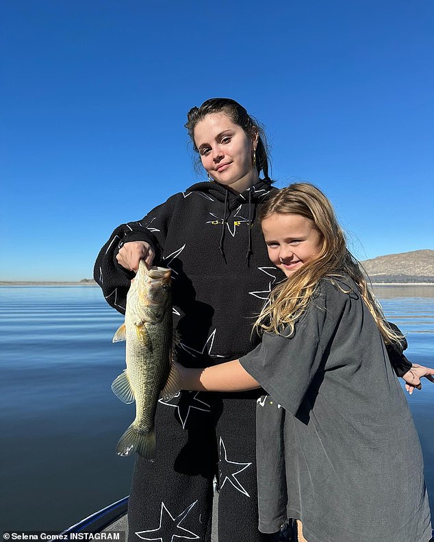 Gone fishing': Here they are seen on a boat after catching a big fish