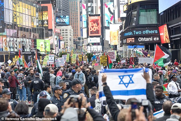 People demonstrate in support of Palestinians and Israelis after the Palestinian militant group Hamas launched an attack on Israel in Times Square on Sunday.