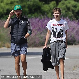 No shoes: Father and son kept their looks casual for the bash and arrived barefoot.  Chris wore gray shorts, a long sleeve gray rash guard and a black insulated vest